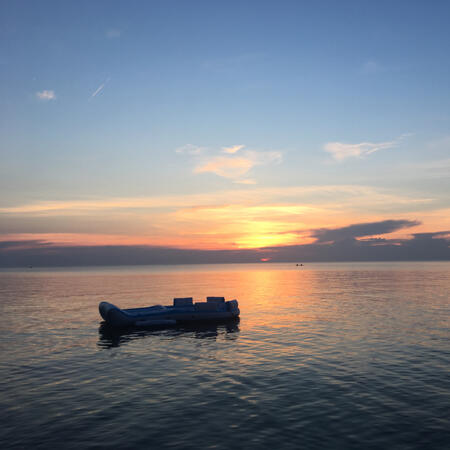 A lake during sunset, a large pool float is in the foreground