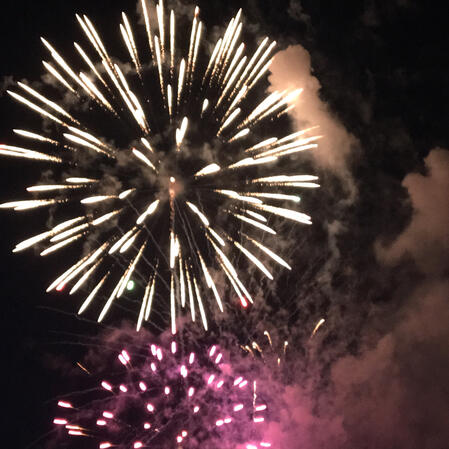 Two fireworks are shown, large is white, small is pink